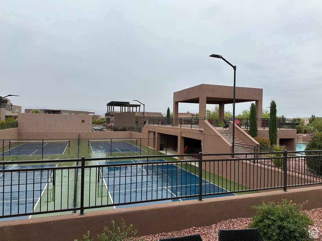View of pool featuring fence and a tennis court