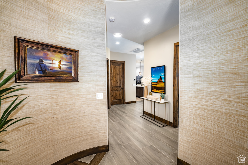 Corridor with baseboards, visible vents, recessed lighting, and wood finished floors