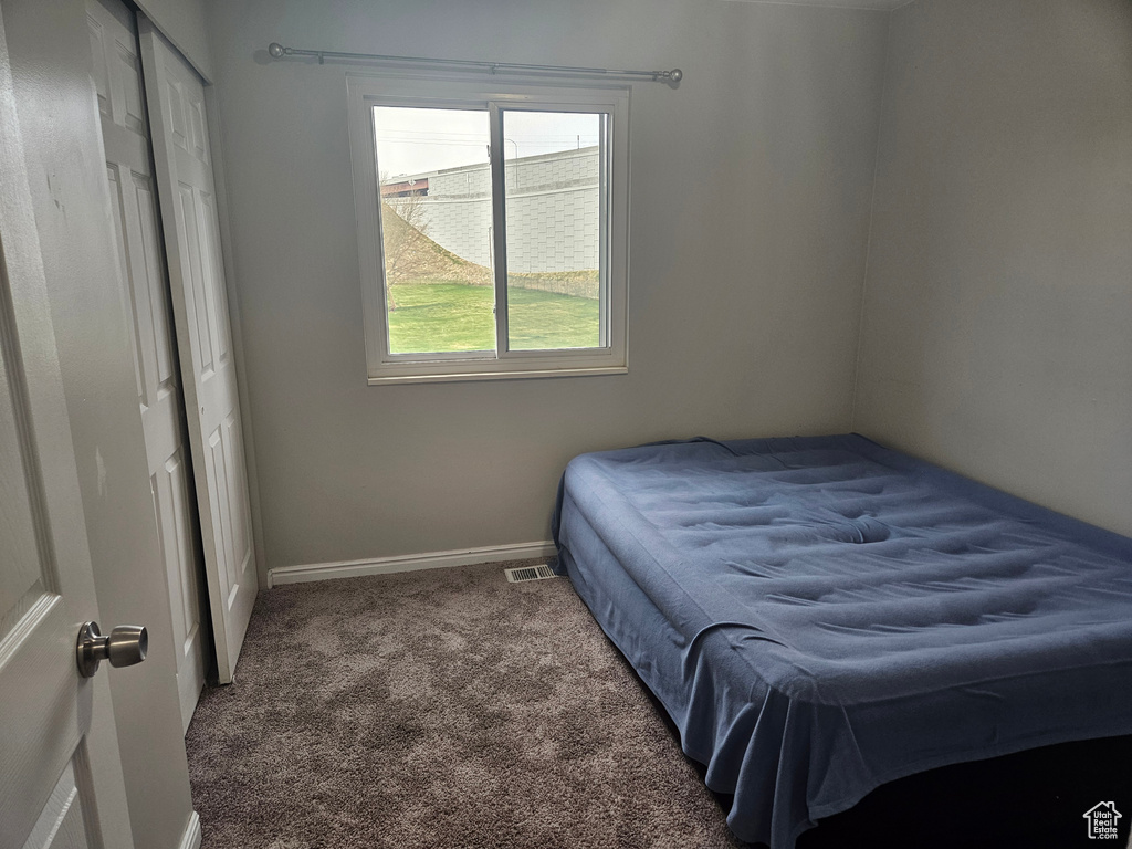 Bedroom featuring visible vents, carpet, baseboards, and a closet