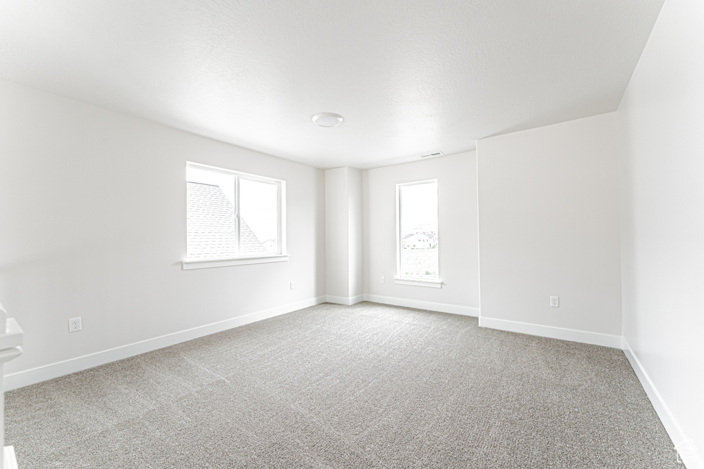 Carpeted empty room featuring baseboards