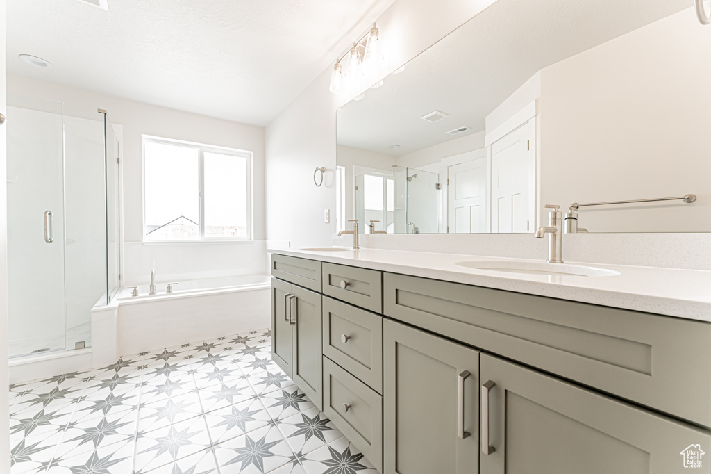 Bathroom with tile patterned floors, double vanity, a bath, and a shower stall