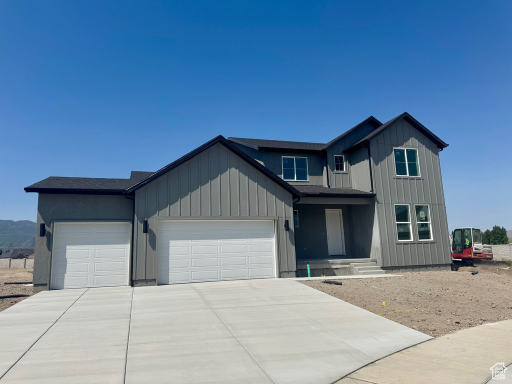 Modern farmhouse style home with an attached garage, concrete driveway, and board and batten siding