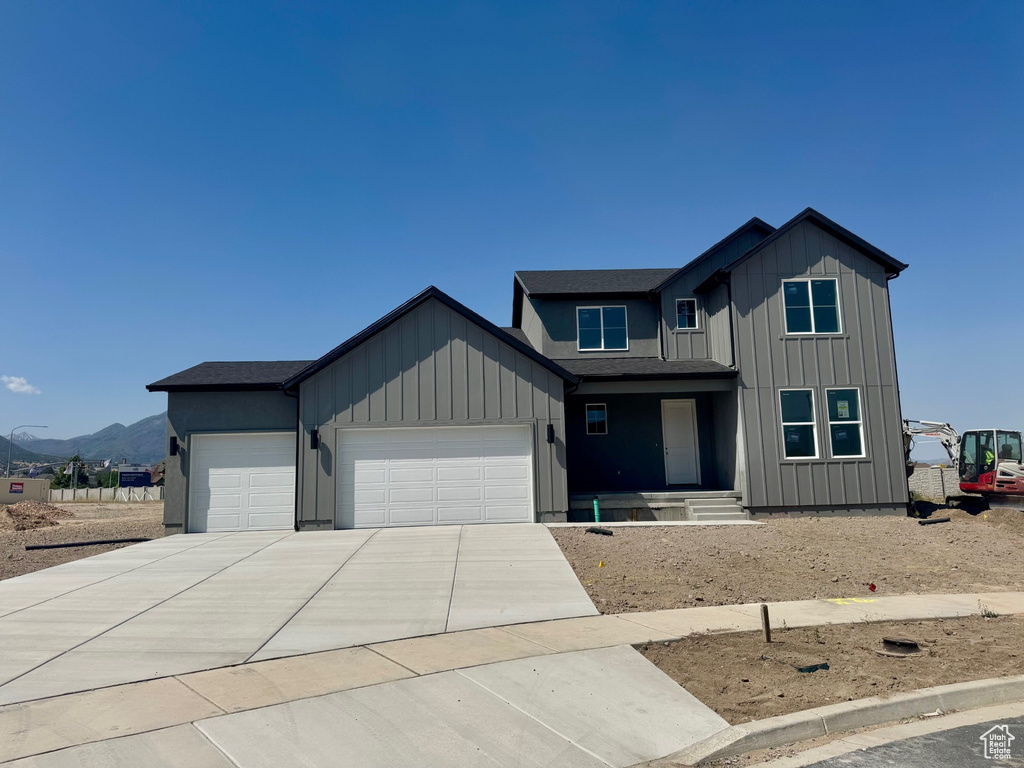 View of front of home featuring a garage, concrete driveway, and board and batten siding