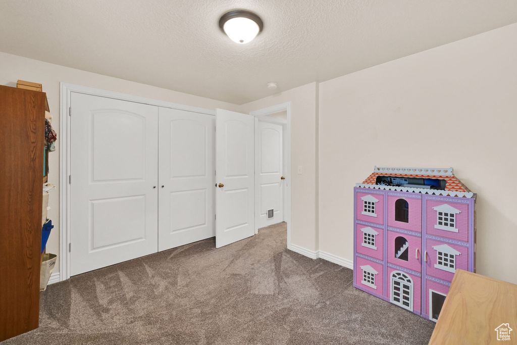 Playroom featuring carpet and a textured ceiling