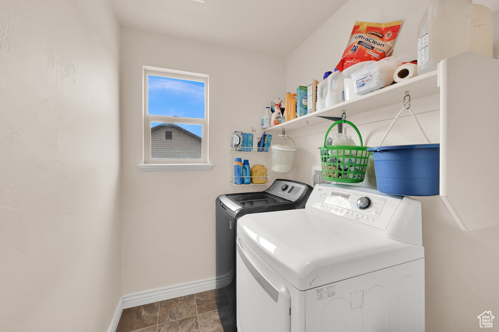 Washroom featuring washing machine and clothes dryer, baseboards, and laundry area