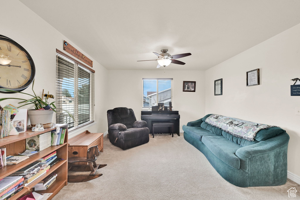 Living area featuring a ceiling fan and carpet floors