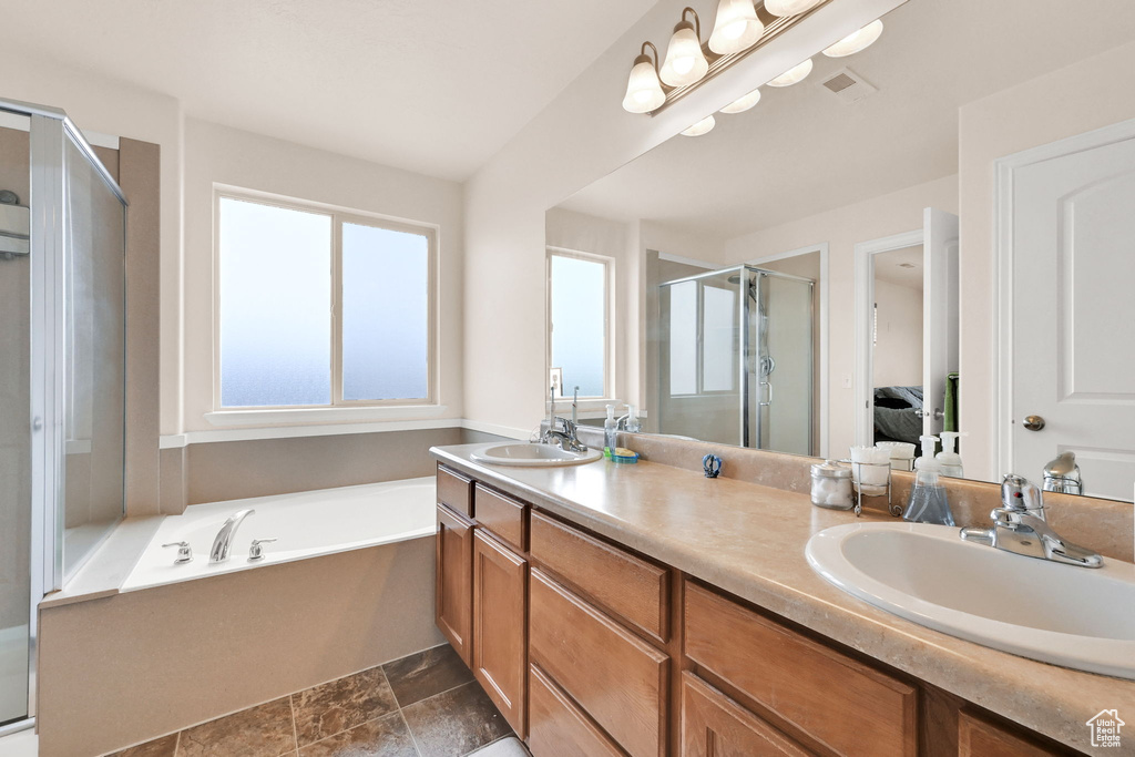 Bathroom featuring a sink, a garden tub, a shower stall, visible vents, and double vanity