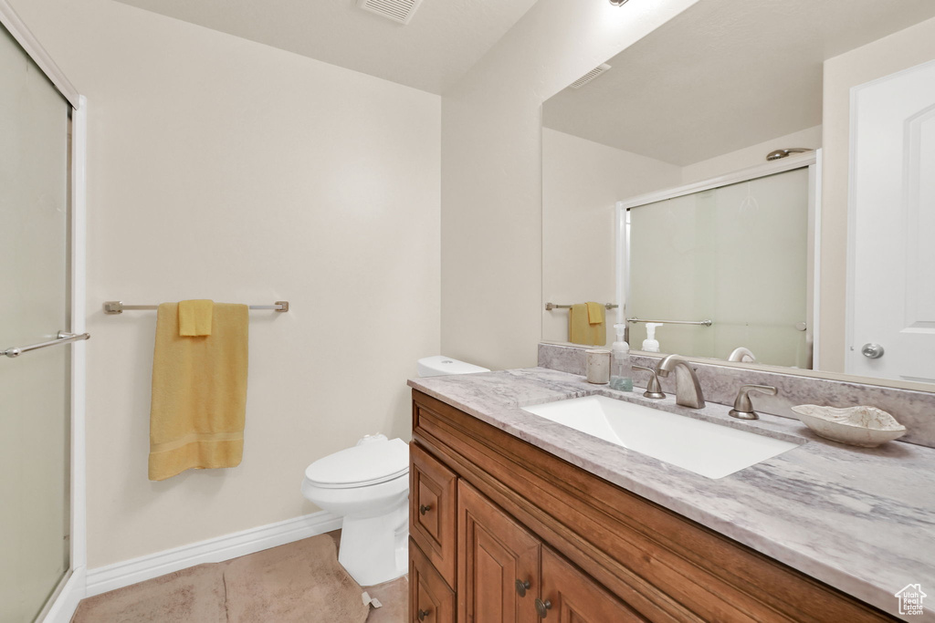 Full bath with a stall shower, toilet, vanity, tile patterned flooring, and baseboards