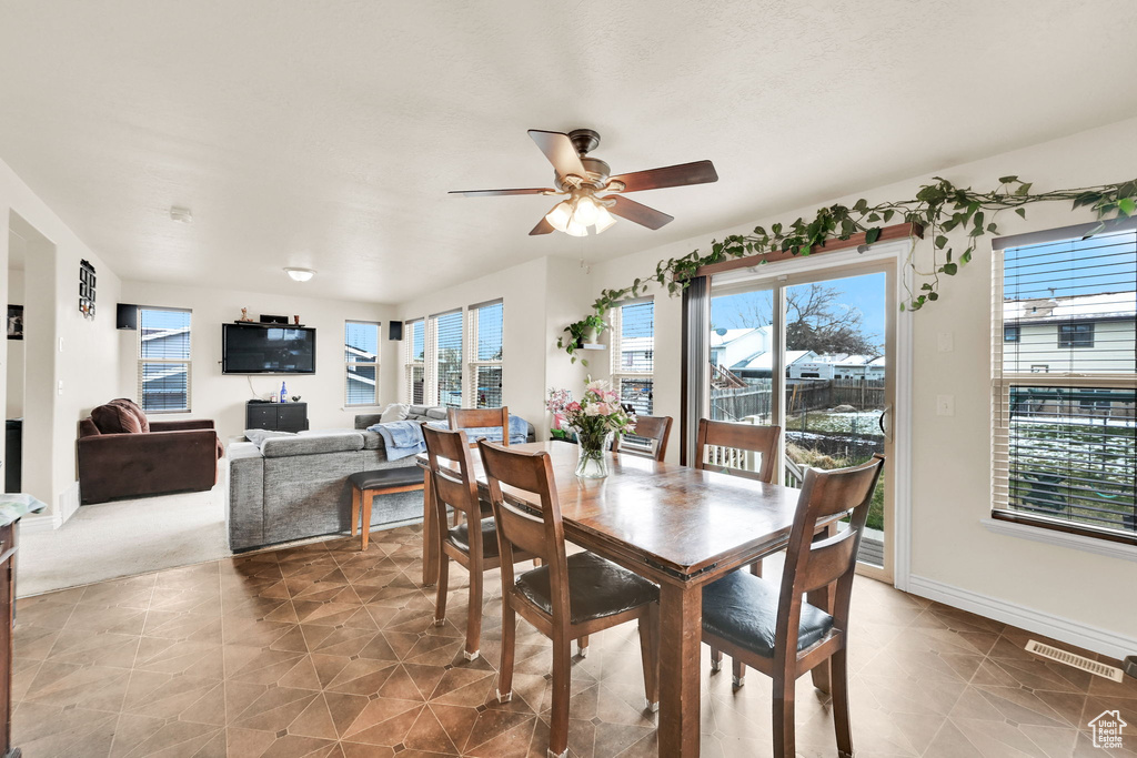 Tiled dining room featuring visible vents, baseboards, and ceiling fan