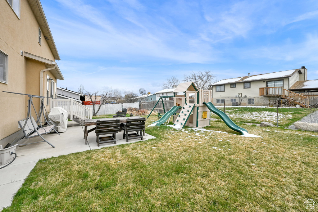 View of yard featuring fence, a residential view, a patio, and a playground