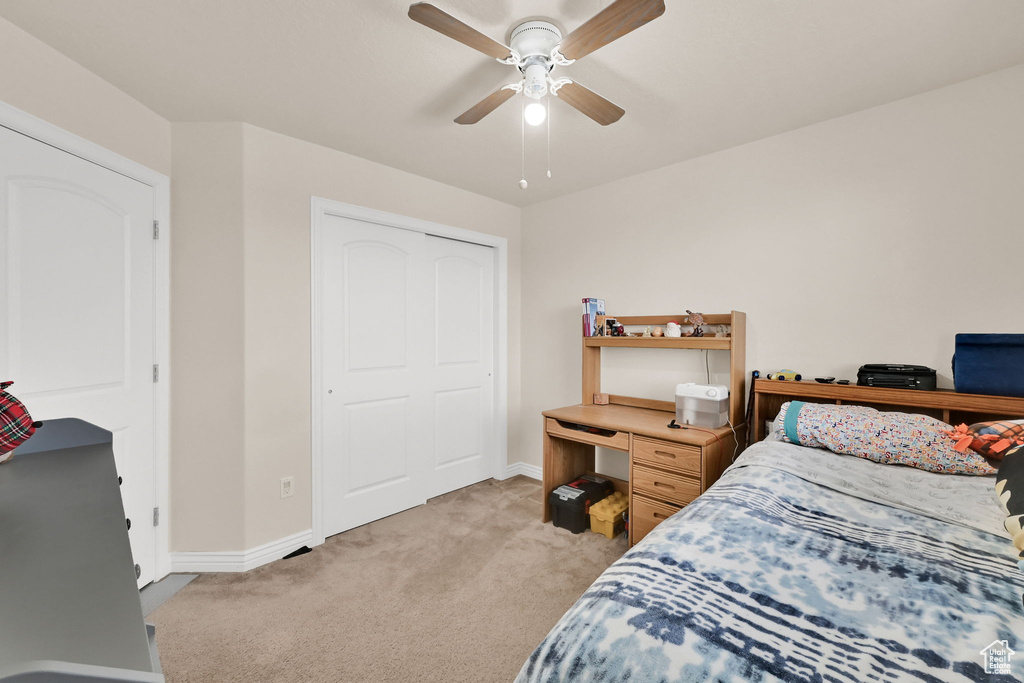 Bedroom with light carpet, baseboards, and a ceiling fan