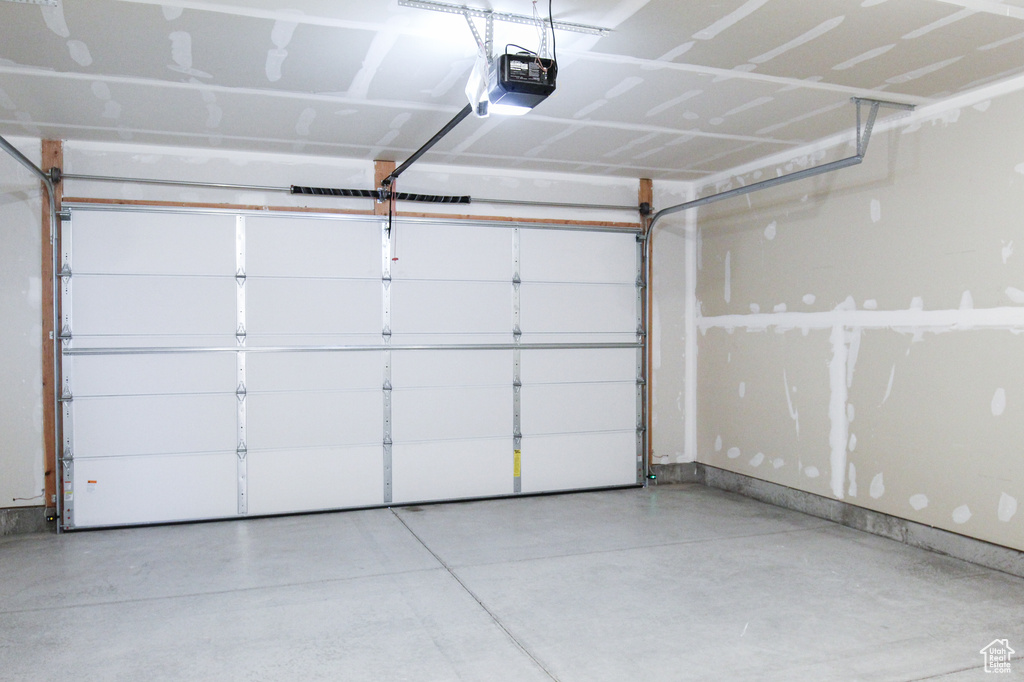 Garage with a garage door opener and baseboards