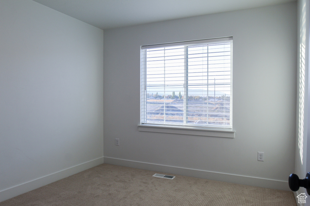 Spare room featuring carpet, baseboards, and visible vents