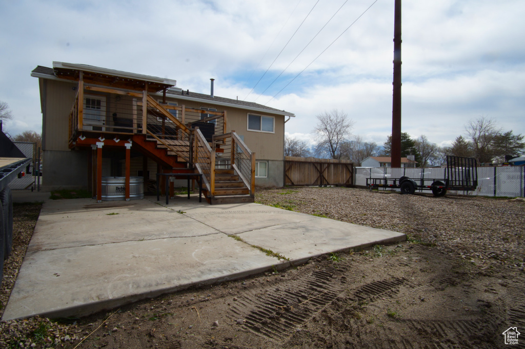 Back of property featuring a patio, stairs, and a fenced backyard
