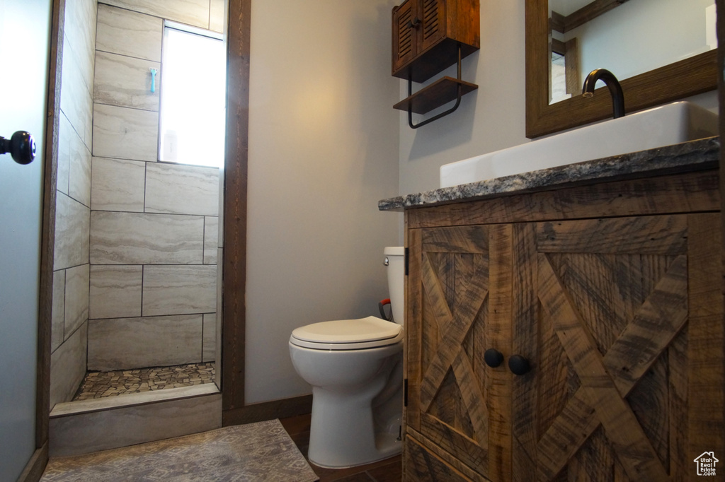 Bathroom with a tile shower, toilet, and vanity