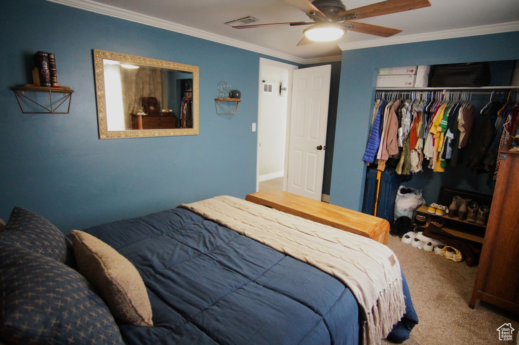 Carpeted bedroom with ornamental molding, a closet, ceiling fan, and visible vents