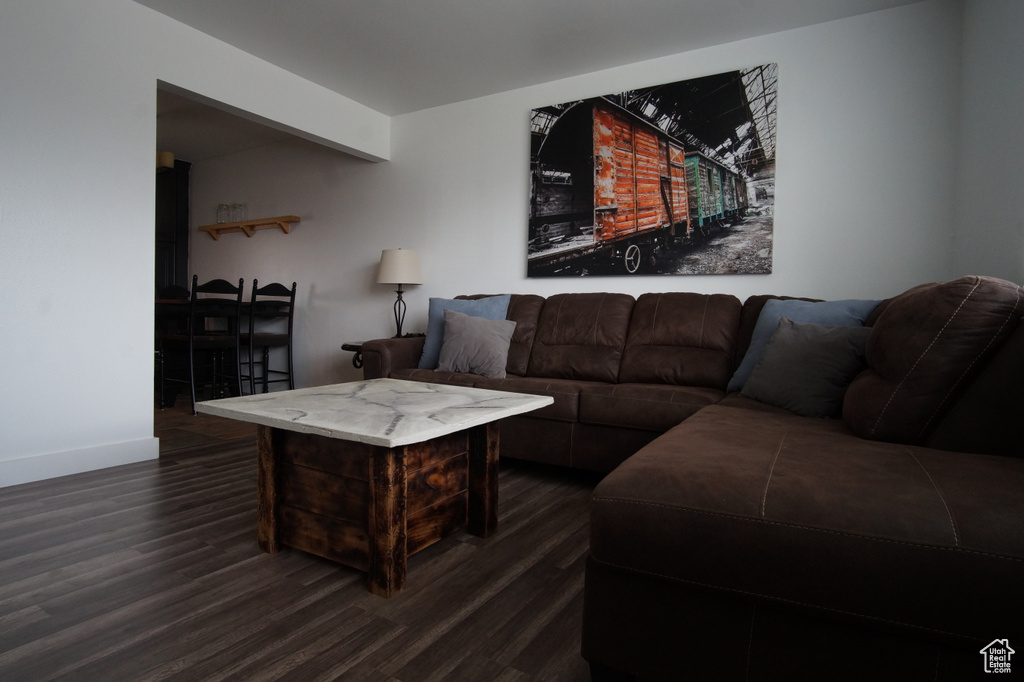 Living area with dark wood-type flooring and baseboards