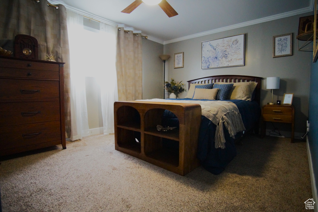 Bedroom with a ceiling fan, ornamental molding, and carpet