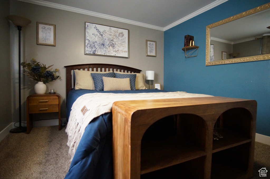 Bedroom with baseboards, ornamental molding, and carpet