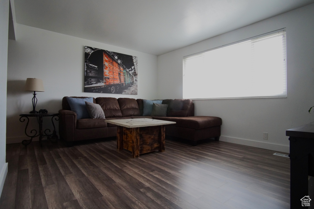 Living room featuring dark wood finished floors and baseboards