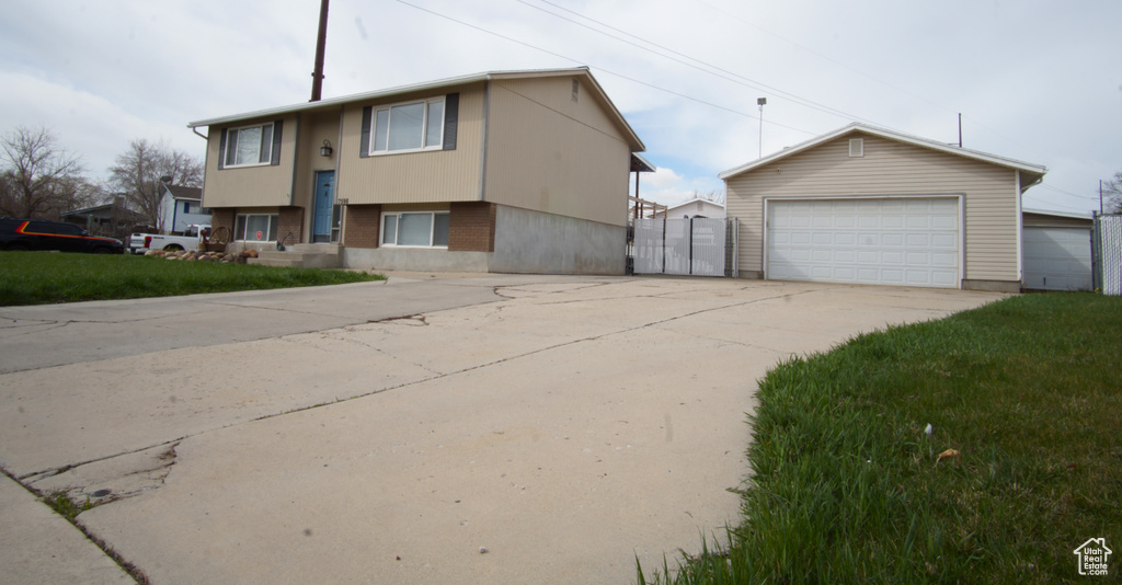 Split foyer home featuring an outdoor structure, a front lawn, and a detached garage