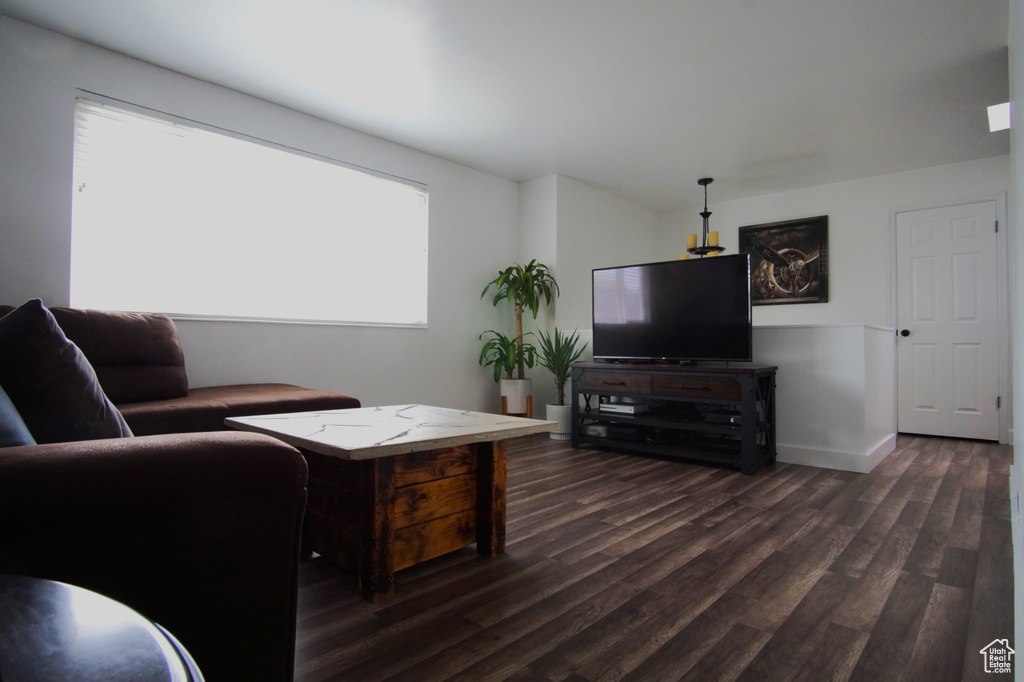 Living room with dark wood-type flooring and baseboards