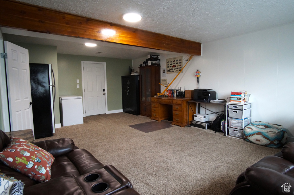 Carpeted living area featuring a textured ceiling and beamed ceiling