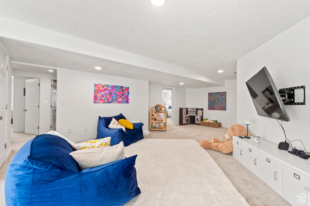 Living area featuring light carpet, recessed lighting, and a textured ceiling