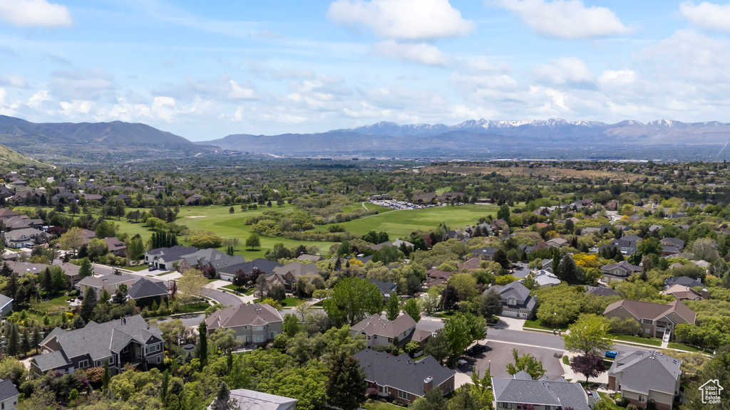 Aerial view of residential area with a mountainous background and a golf course