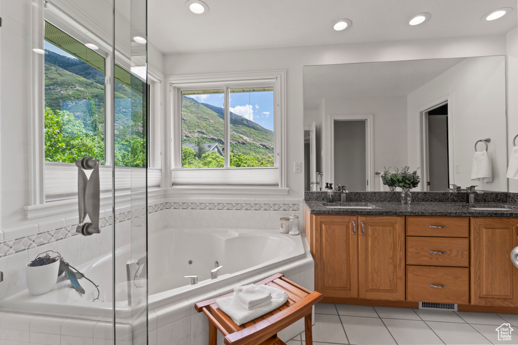 Bathroom with a whirlpool tub, double vanity, tile patterned floors, and recessed lighting