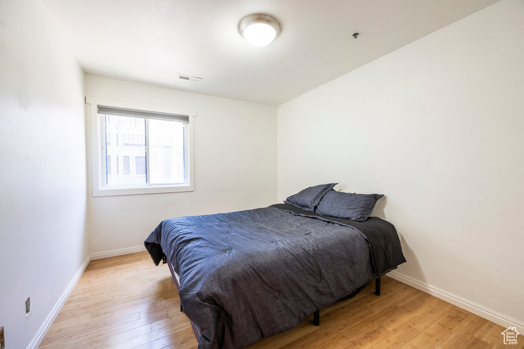 Bedroom with light wood finished floors and baseboards