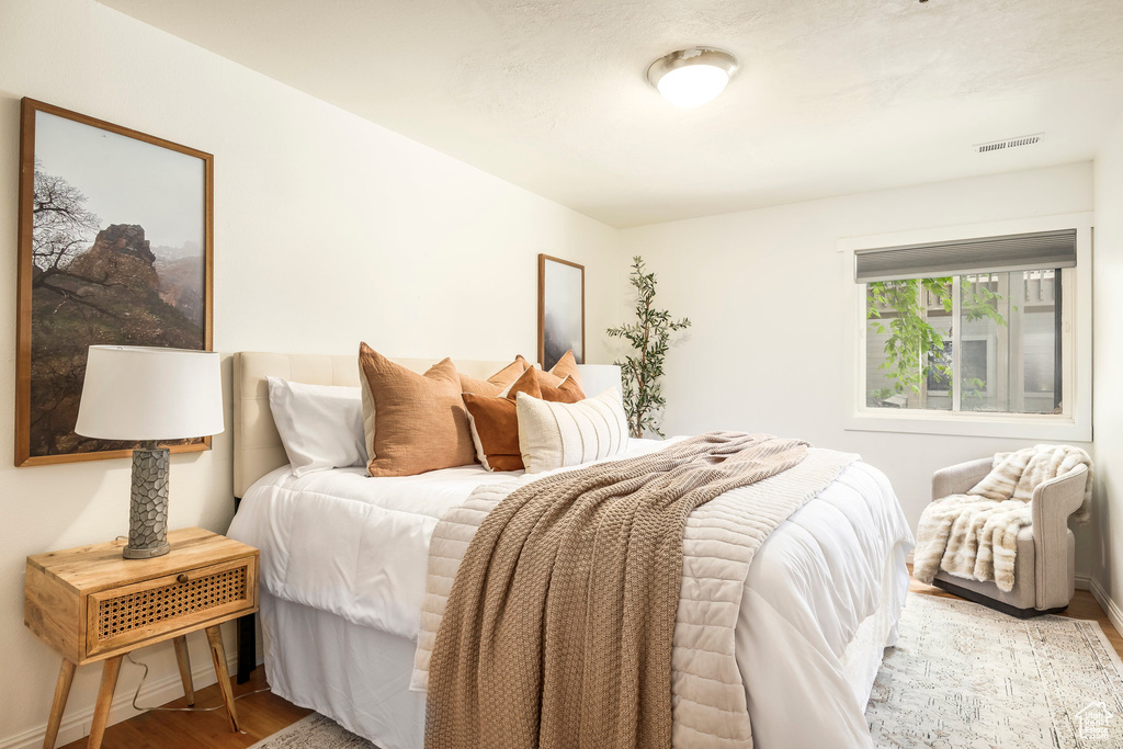 Bedroom with wood finished floors and baseboards