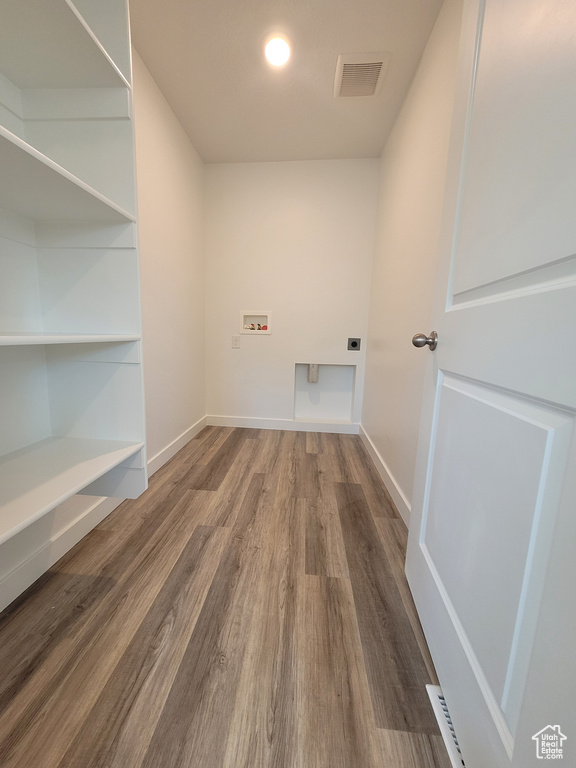 Laundry area with hookup for an electric dryer, hookup for a washing machine, and wood finished floors