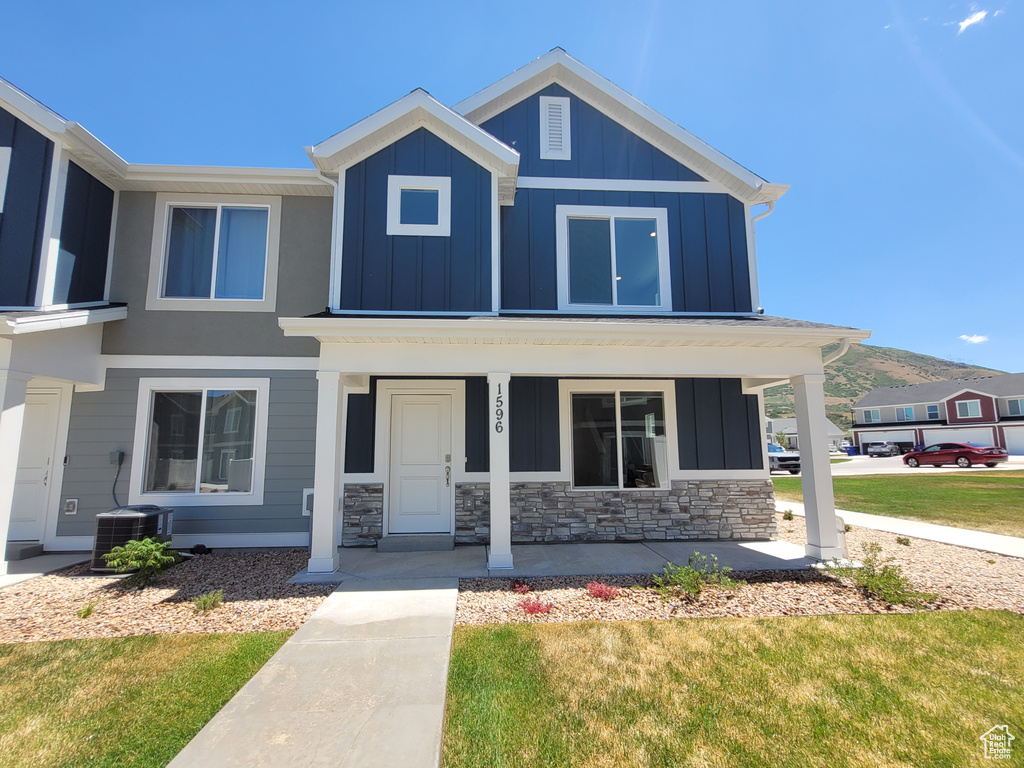 View of front of house with board and batten siding, a porch, and stone siding