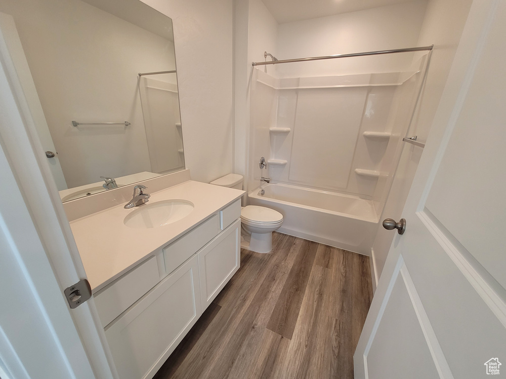 Bathroom featuring vanity, wood finished floors, and bathing tub / shower combination