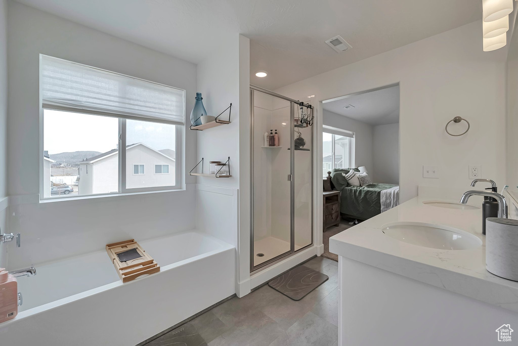 Full bathroom featuring plenty of natural light, visible vents, a bath, and a shower stall