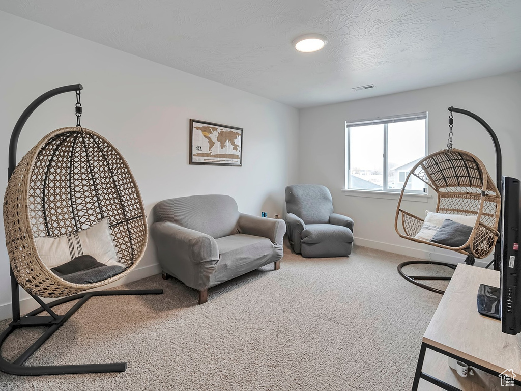Sitting room with baseboards, visible vents, carpet floors, and a textured ceiling