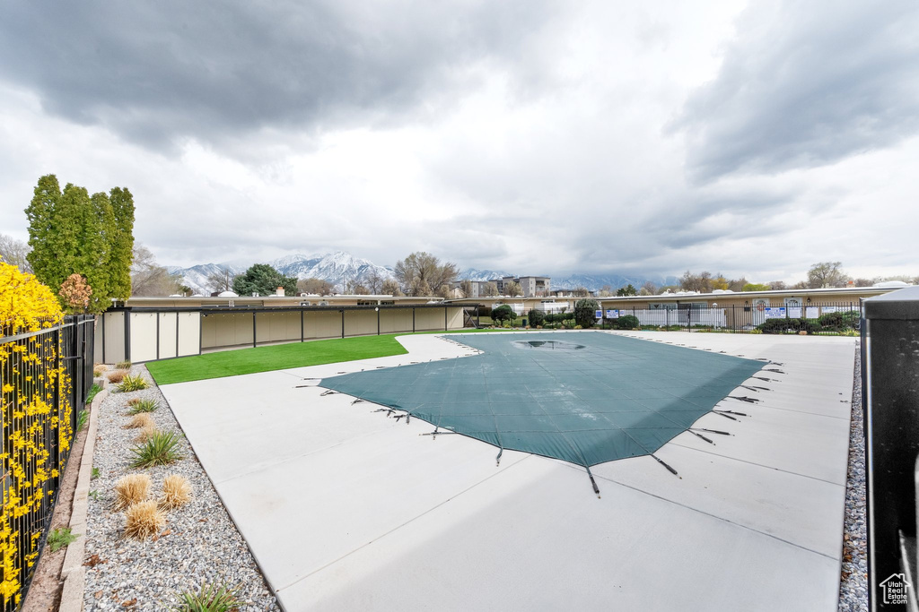 View of swimming pool with a patio area, a fenced backyard, and a mountain view