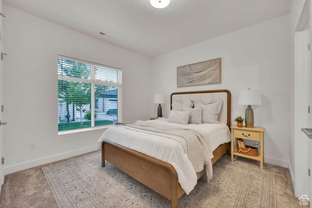Bedroom with baseboards and light carpet