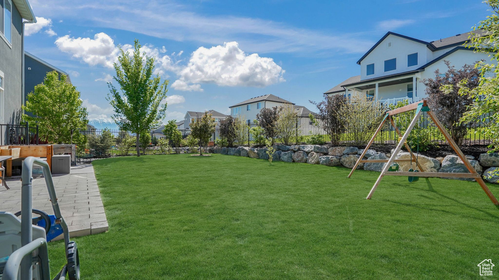 View of yard with a residential view, a fenced backyard, and a playground