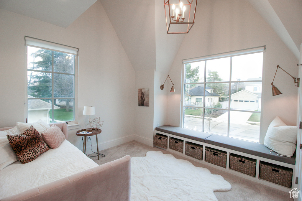 Carpeted bedroom featuring access to outside, baseboards, lofted ceiling, and a chandelier