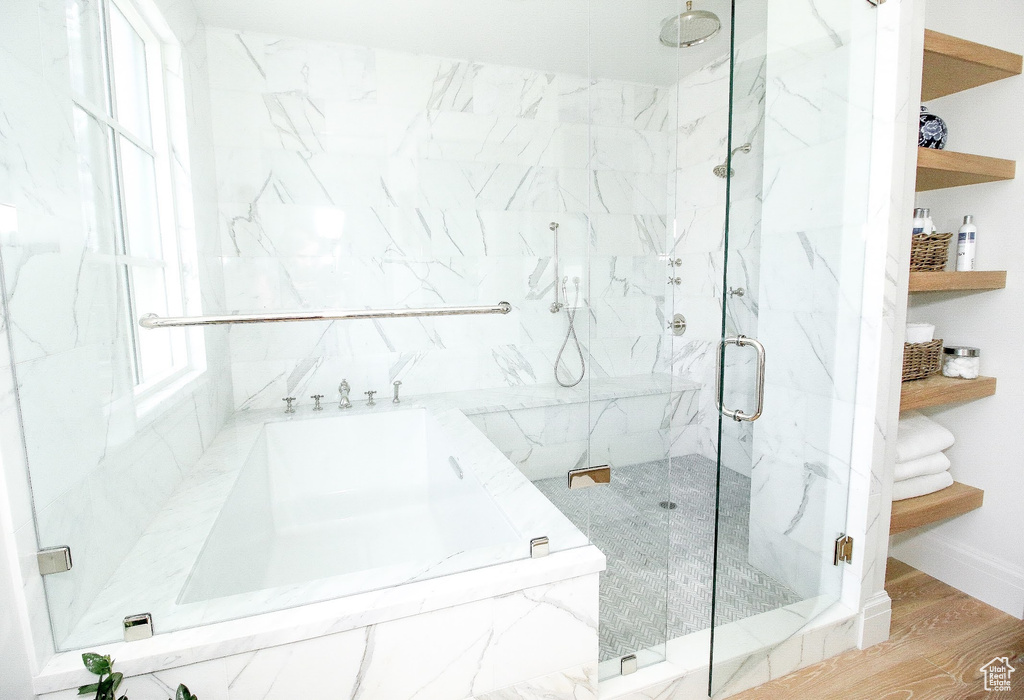 Full bath with baseboards, a marble finish shower, and wood finished floors