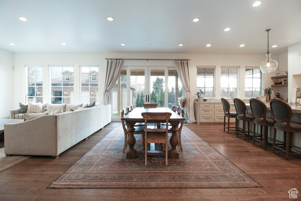 Dining area with dark wood-style flooring, a wealth of natural light, and recessed lighting