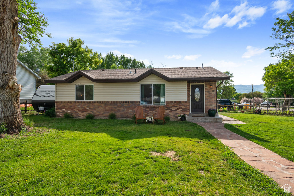 View of front of property featuring brick siding and a front lawn