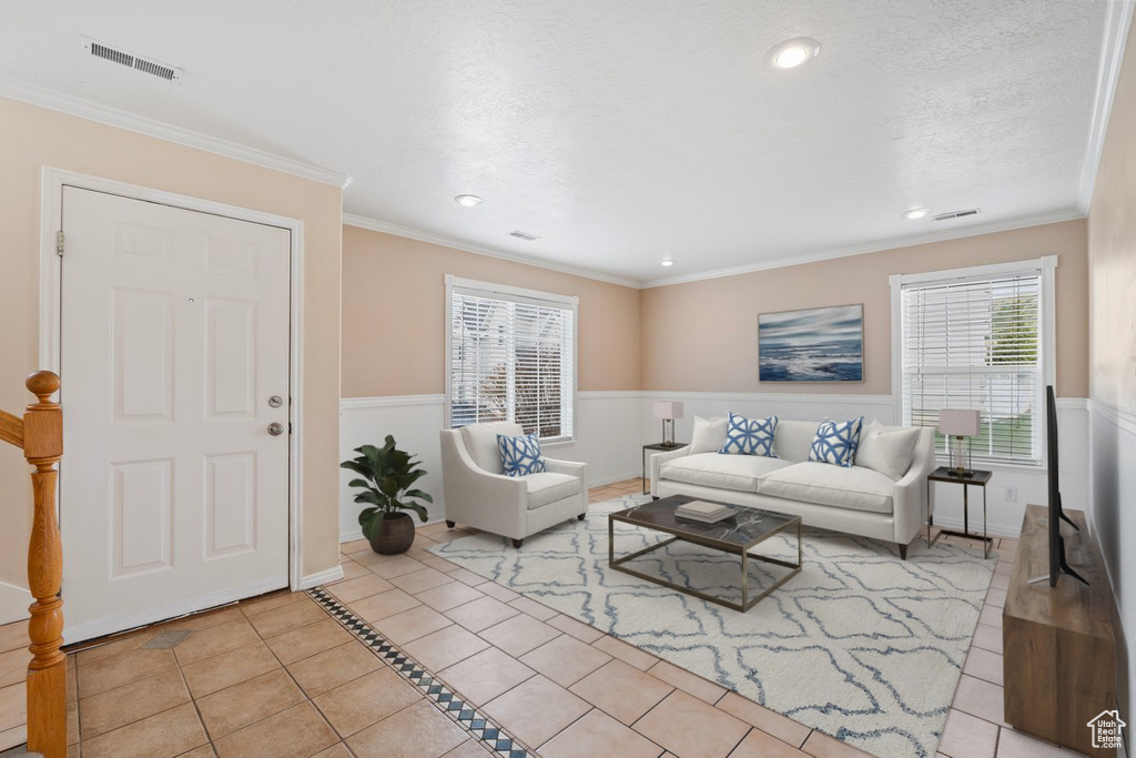 Tiled living room featuring baseboards, recessed lighting, and ornamental molding