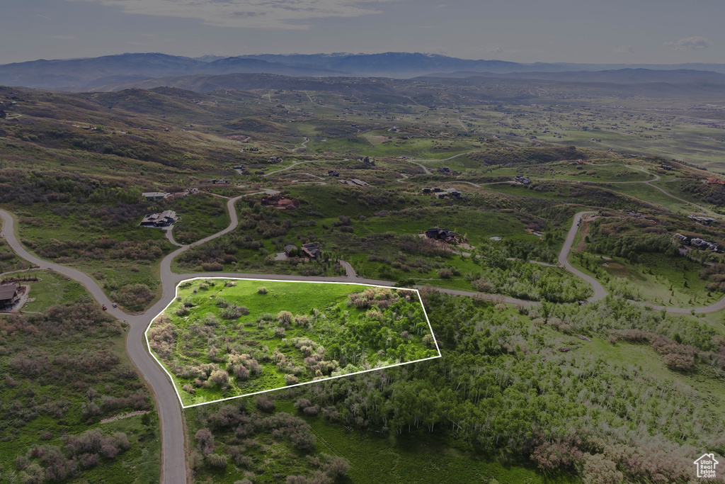 Aerial overview of property's location featuring a mountainous background and property boundaries highlighted