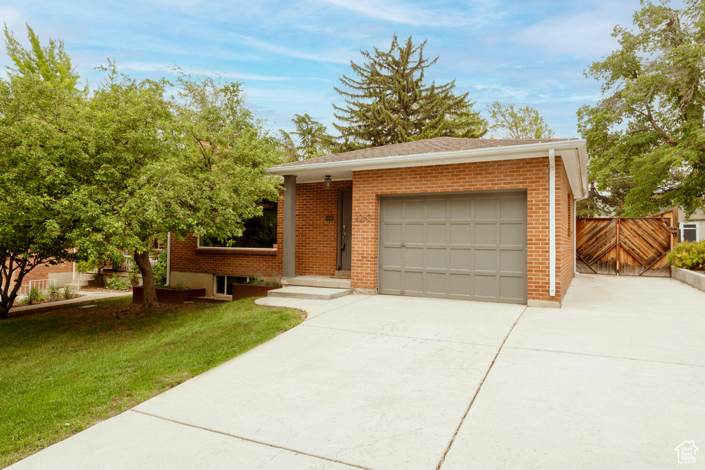 Ranch-style home featuring driveway, brick siding, and a garage