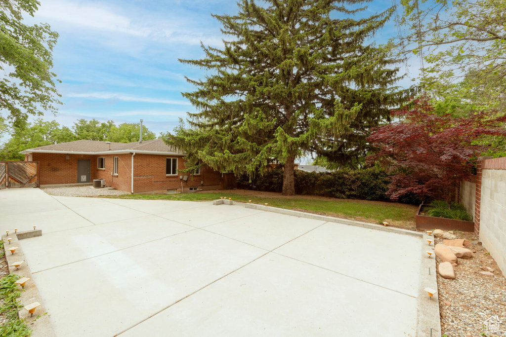 View of patio featuring central AC unit and fence