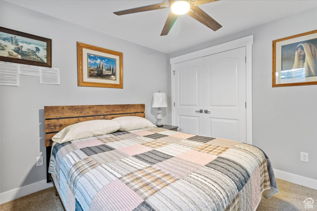 Bedroom featuring carpet floors, a closet, baseboards, and ceiling fan