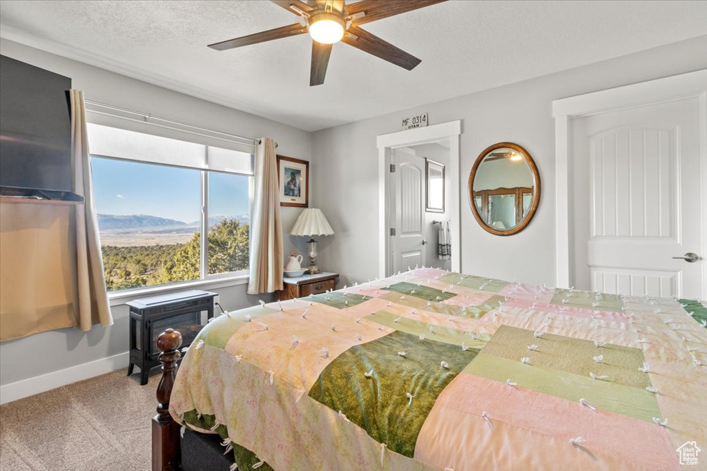 Carpeted bedroom with baseboards and a ceiling fan